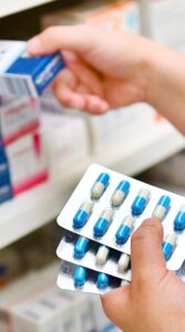 Counting pills on pharmacy shelf