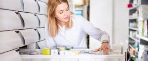 Pharmacist checking stock in a draw of her pharmacy